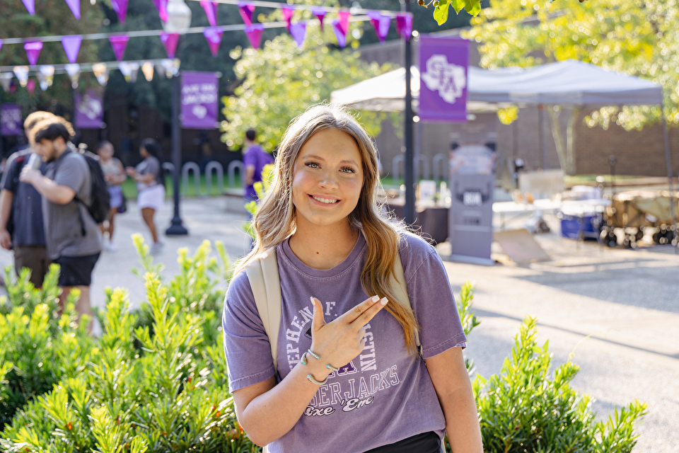 A student poses with an "Axe Em" hand sign