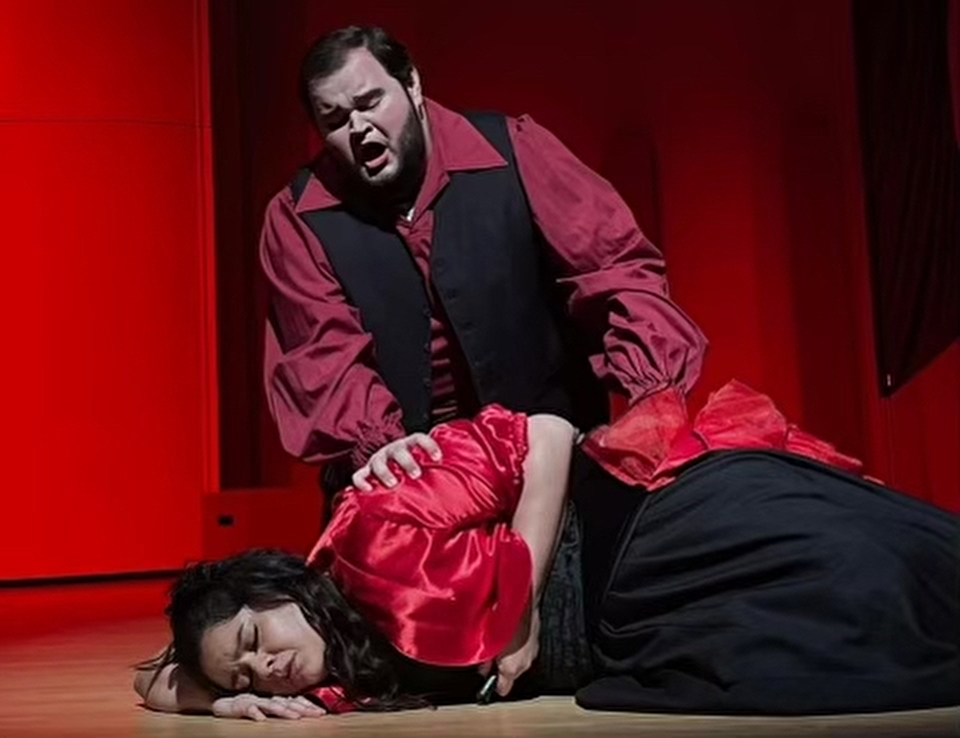 Male and female opera singers in costume performing a scene from “Carmen”