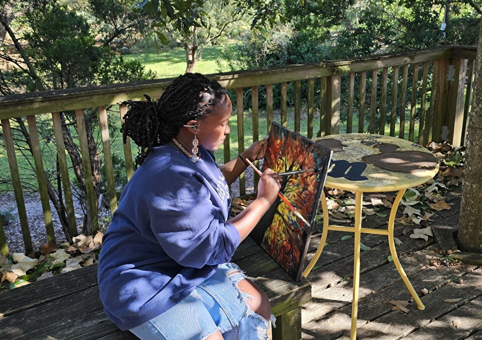 Photo of Monique Coleman painting fall foliage