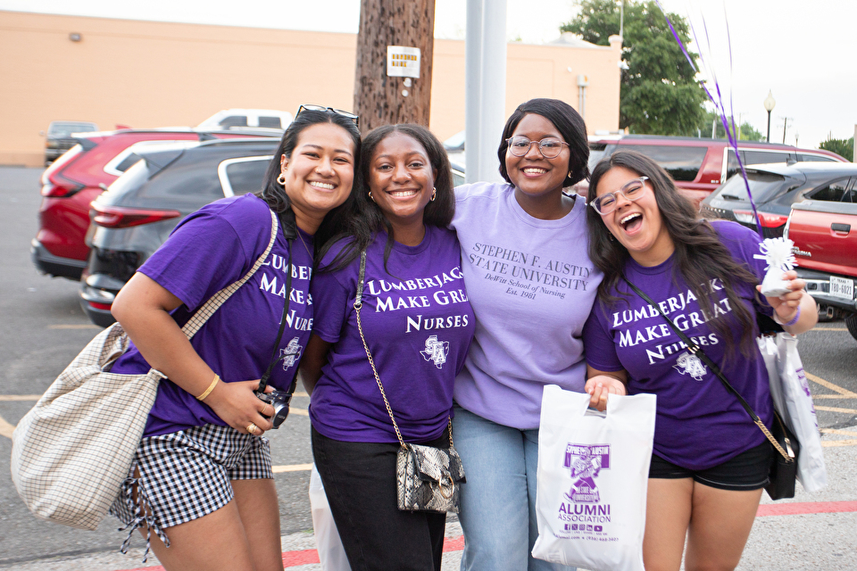 Students pose together, all wearing purple