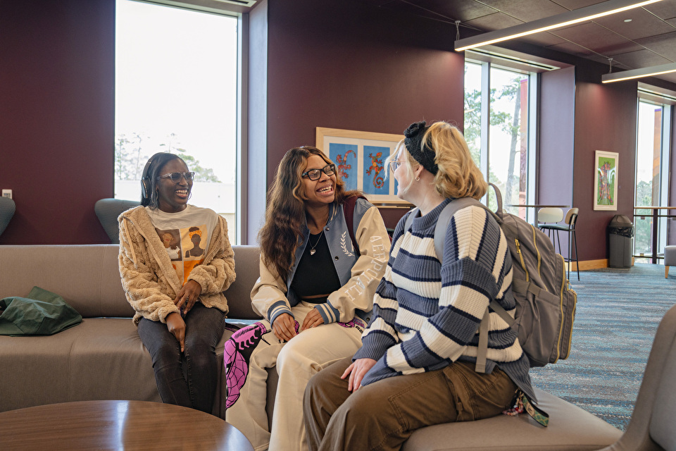 Three students sit and chat