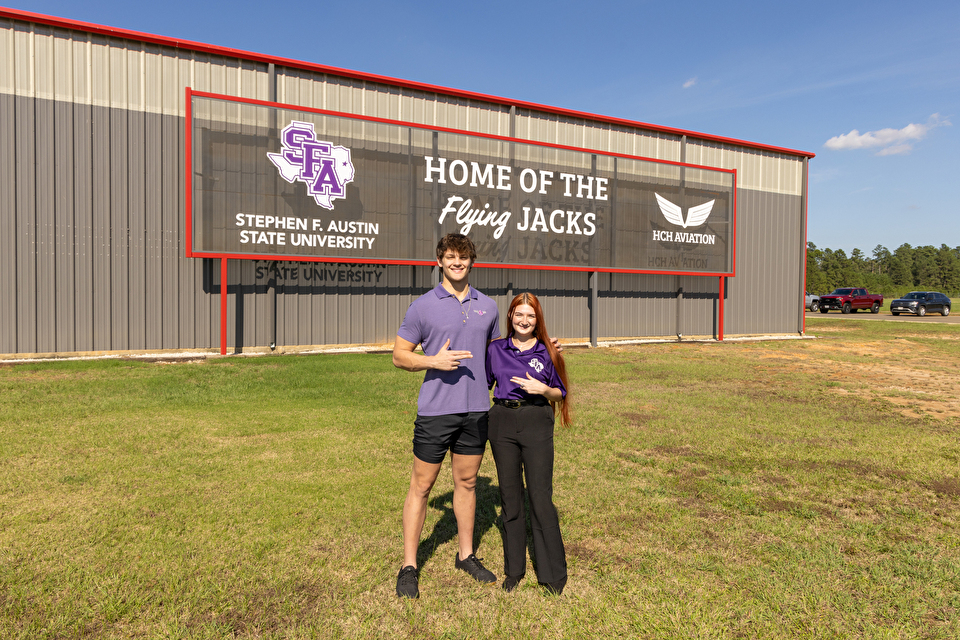 Two students stand outside the Flying Jacks building at the Airport where aviation classes are held.